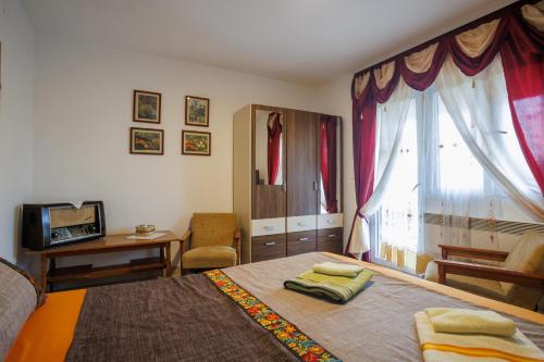 a bedroom with a bed and a desk and a window at Oasis of Peace Meterizi in Cetinje