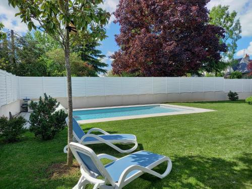 two lawn chairs sitting next to a swimming pool at La Chouette d'Amboise in Amboise