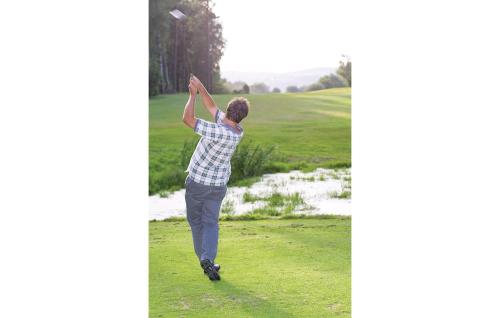 a man is reaching up to catch a golf ball at Beautiful Home In Vessigebro With Sauna in Vessigebro