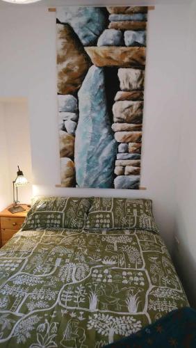 a bedroom with a bed with a painting on the wall at The Studio in Orkney