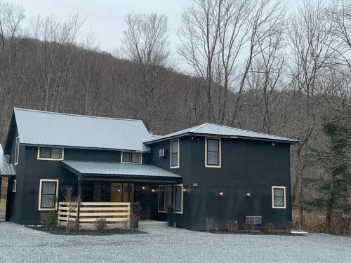 a black house with a gambrel roof at Starlite Motel & Suites in Big Indian