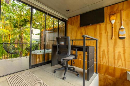 an office with a desk and a chair on a balcony at Casa Natu Ilhabela Portinho in Ilhabela