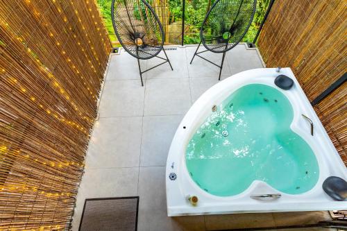 a bath tub in the middle of a patio with chairs at Casa Natu Ilhabela Portinho in Ilhabela