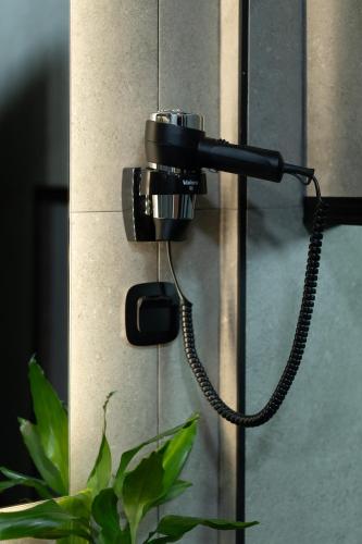 a camera hanging on a wall next to a plant at The Beehive in Mytilini