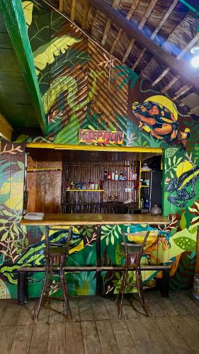 a bar with a colorful wall and two chairs at The Humpback Turtle in El Valle