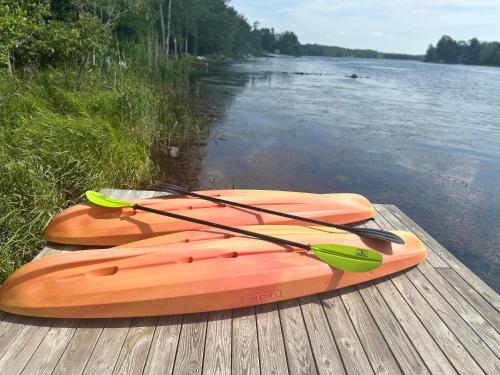 an orange kayak sitting on a dock next to the water at Majestic Lake Front Chalet in Tobyhanna