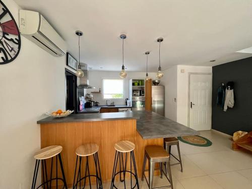 une cuisine avec un comptoir et un bar avec tabourets dans l'établissement Maison Lili 2 chambres - 4pers, à Conca