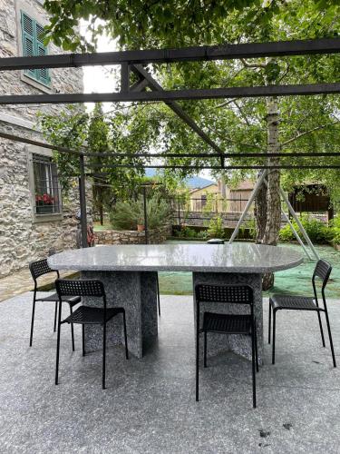 a large concrete table with four chairs under a tree at Crosa Rosella in Bardineto