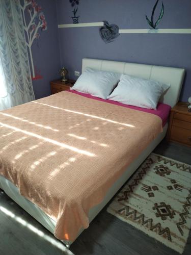 a bedroom with a large bed with a brown blanket at Miladinović Bistrica in Bistrica