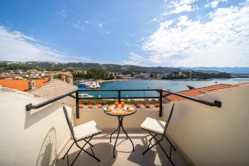 a balcony with a table and chairs and a view of the water at Kaldanac Residence in Rab