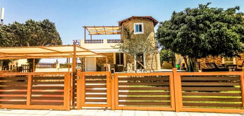 a wooden fence with an umbrella in front of a house at Casa Bella a Skala 3 in Skala Kefalonias
