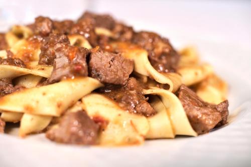 a pile of pasta with meat and sauce on a plate at Antica Locanda Luigina in Mattarana