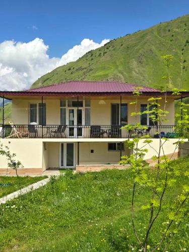 a house with a hill in the background at Hotel Garbani in Stepantsminda
