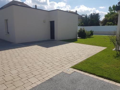 a white building with a door in a yard at La Chouette d'Amboise in Amboise