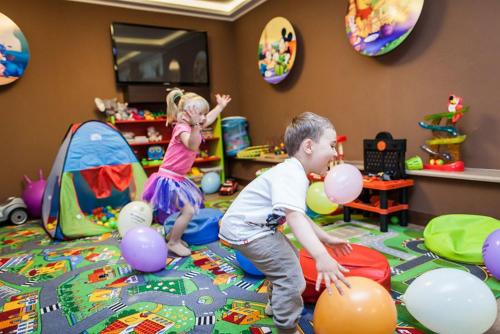 a boy and a girl playing with balloons in a play room at Hotel 77 Restauracja Spa in Chałupy