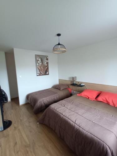 une chambre avec deux lits et une lampe dans l'établissement Le coteau 3 chambres, à Charmes