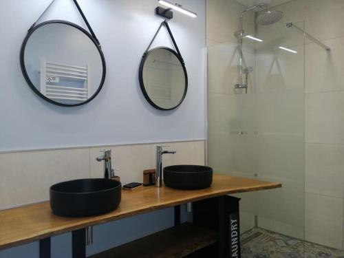 une salle de bain avec deux lavabos et un miroir dans l'établissement Les Ganivelles, maison à 350 m de la plage, à Bretteville-sur-Ay