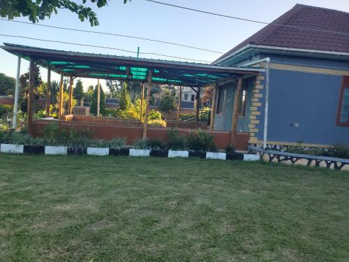 a pavilion with a bench in a yard at Alice Gardens and Campsite in Entebbe