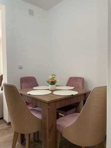 a wooden table with chairs around it with a vase on it at Apartmani Vrla NEW in Vladičin Han