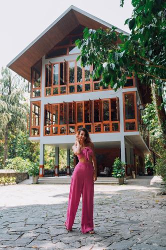a woman talking on a cell phone in front of a building at Moksha at Kitulgala - Rainforest Boutique Hotel in Kitulgala