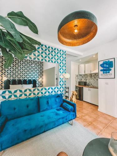 a living room with a blue couch and a kitchen at CerezinoFlats- Blue Bay Studio in Seixal