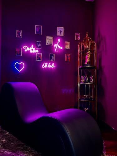 a room with a bed and neon signs on the wall at Suite mit Whirlpool, Sauna, Pole Dance und mehr in Essen