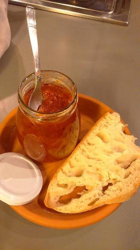 a plate with a jar of jam and a piece of bread at Corte di Maggio B&B Country House in Imola