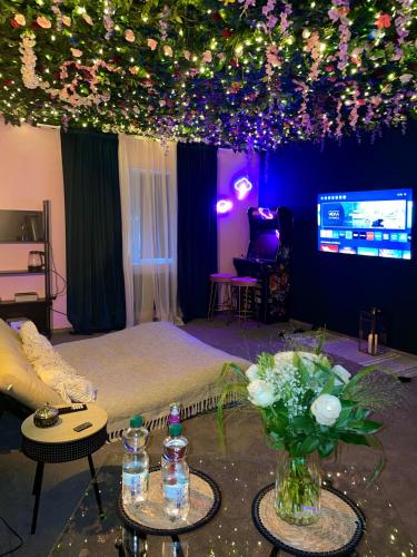 a room with a bed with flowers and lights at Suite mit Whirlpool, Sauna, Pole Dance und mehr in Essen