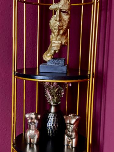a black and gold shelf with a statue and a vase at Suite mit Whirlpool, Sauna, Pole Dance und mehr in Essen