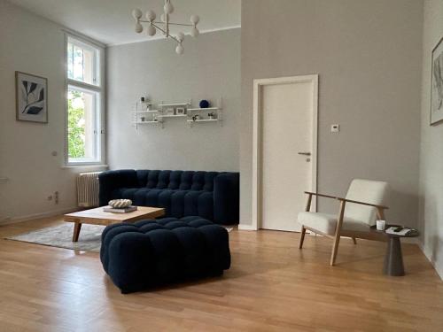 a living room with a blue couch and a table at Ferienwohnungen Leipzig Musikviertel Zentrum Süd - zentral und dennoch ruhig in Leipzig