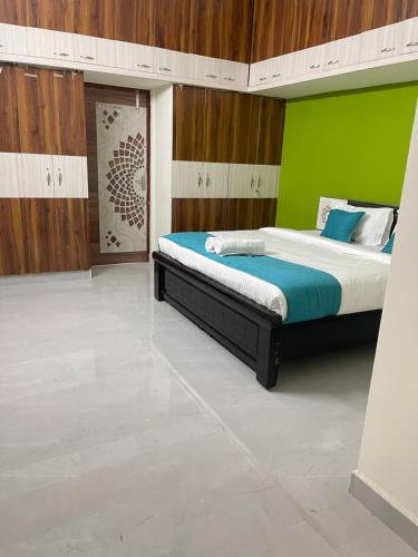 a bedroom with a bed with a green wall at Sun Home Stays - Spacious Rooms - New Property - Pleasant Location in Tirupati
