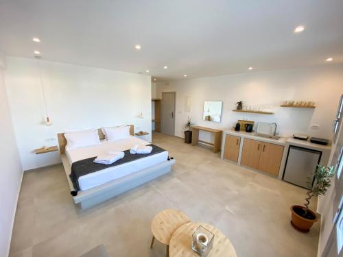 a large bedroom with a bed and a kitchen at Nohēme Luxury Suites in Vourvoulos
