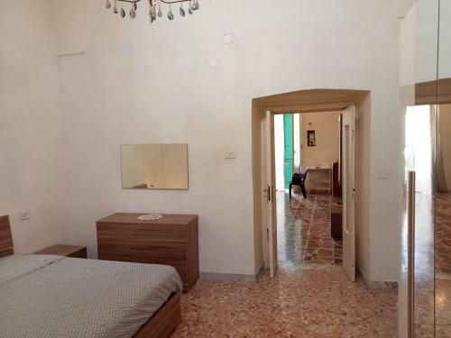 una camera con letto e specchio e un corridoio di Dimora storica Principi di Savoia a Lecce