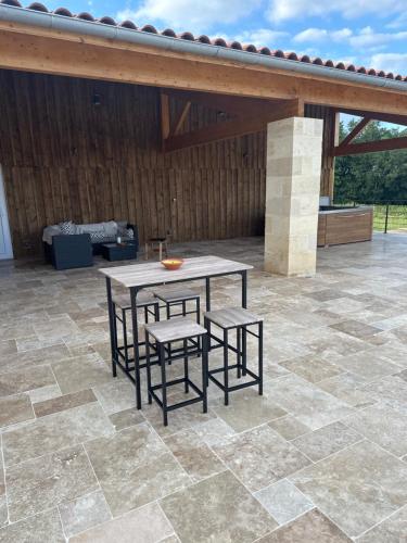 a patio with a table and chairs on a patio at Maltus - Le Repaire de Maltus "Gîtes & Spa" in Lussac
