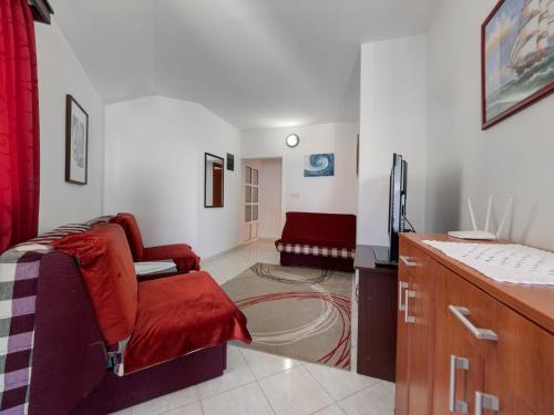 a living room with a red chair and a couch at Apartments Marina in Sveti Stefan