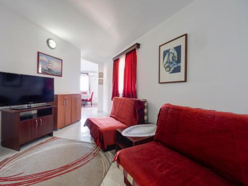 a living room with red furniture and a flat screen tv at Apartments Marina in Sveti Stefan