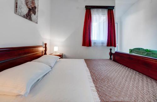 a bedroom with a large bed with a red window at Apartments Marina in Sveti Stefan