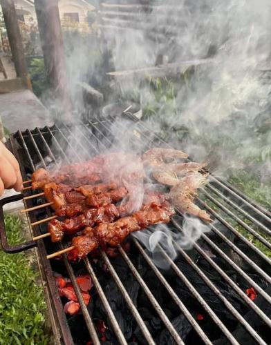 a bunch of meat cooking on a grill at Rustic Log Cabin in Tagaytay in Tagaytay