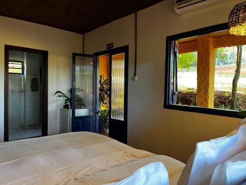 a bedroom with a bed and a window at Hospedaria do Feno in Brotas