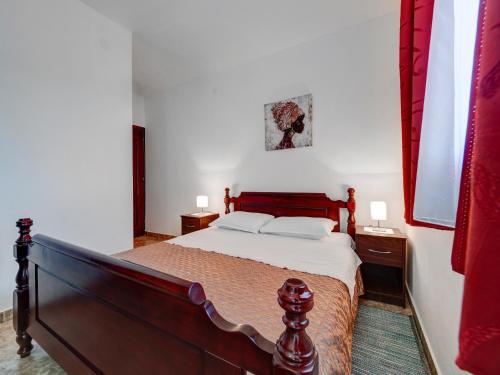 a bedroom with a large bed with red curtains at Apartments Marina in Sveti Stefan