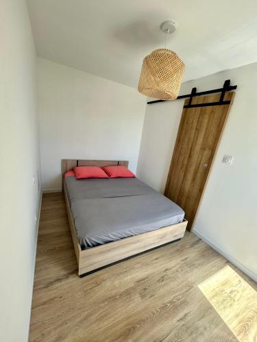 - une chambre avec un lit doté d'oreillers rouges dans l'établissement Appartement moderne, au Cap d'Agde