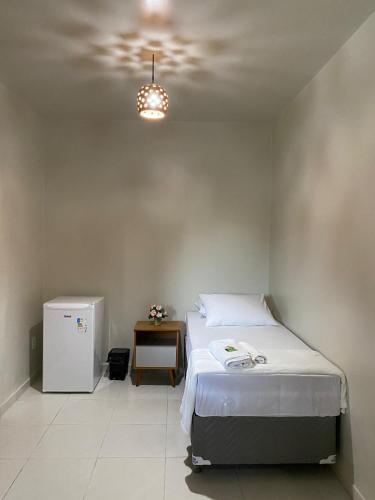 a bedroom with a bed and a small refrigerator at Pousada Sitio Parque dos Lençóis in Barreirinhas