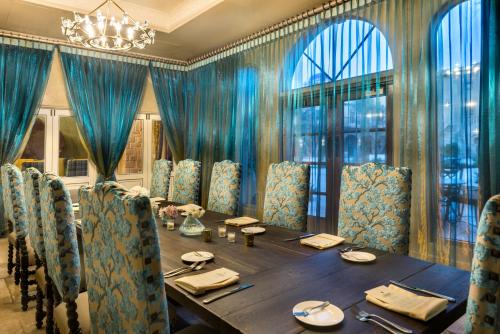a dining room with a table and blue curtains at Allegretto Vineyard Resort Paso Robles in Paso Robles
