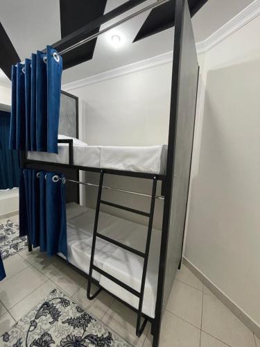 un letto a castello in una stanza con tende blu di Asia Hostel a Tashkent