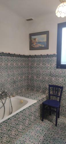 une salle de bain avec une baignoire, une chaise et un tableau dans l'établissement La Villa Toulonnaise-Jardin-Espace, à Toulon