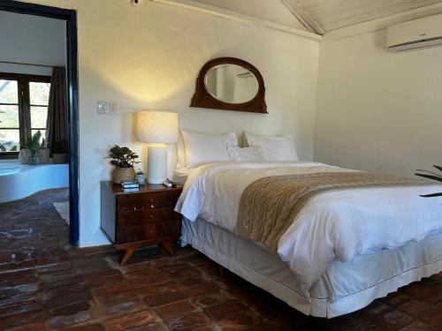 a bedroom with a large bed and a mirror at Hospedaria do Feno in Brotas