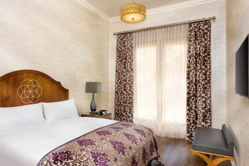 a hotel room with a bed and a window at Allegretto Vineyard Resort Paso Robles in Paso Robles