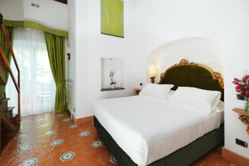 a bedroom with a large bed with white sheets at Hotel Botanico San Lazzaro in Maiori