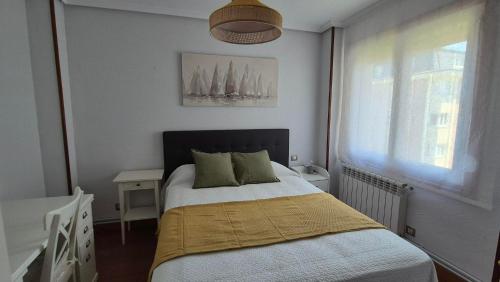 a bedroom with a bed with two pillows and a window at El Espolón de Valdenoja in Santander