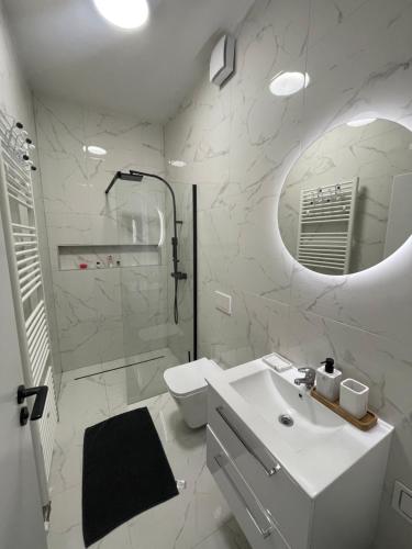 un bagno con lavandino, WC e specchio di Novostavba v centre + parking a Banská Bystrica